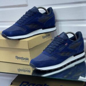 A pair of navy blue Reebok Classic sneakers on display, showcasing their sleek design and comfortable features.