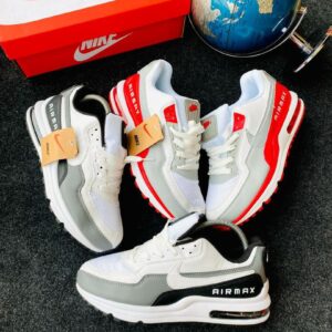 A pair of white and grey Nike Air Max shoes with a red Nike box and a blue globe in the background, perfect for sneaker enthusiasts in Nigeria.
