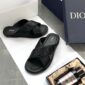 A pair of black Dior slides on a white background, showcasing the high-class design and comfort of these luxury sandals.
