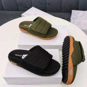 Luxury ARTICLE men's slides in black and olive green, showcased on white boxes, highlighting the high-quality materials and sleek design.