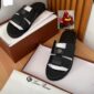 Luxury black slides with two straps and a logo on top, placed in a brown box with white paper and a white cloth bag with 'Loro Piana' logo.