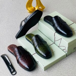 A stylish arrangement of luxurious crocodile leather half shoes in various colors, accompanied by shoe boxes and a shoe horn, exuding high-end quality and sophistication.