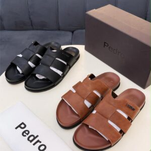 A pair of luxurious black and brown leather sandals from Pedro, accompanied by a matching box and dust bag, exuding high-end quality and sophistication.