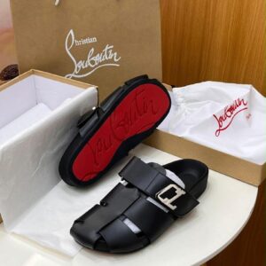 A pair of luxurious black Christian Louboutin sandals with a red sole, accompanied by a brown shopping bag and white shoe box.