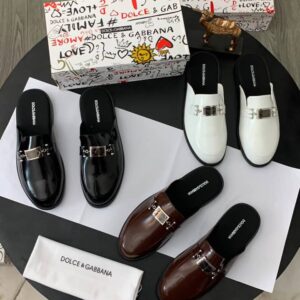 A luxurious display of Dolce & Gabbana loafers in black, brown, and white, accompanied by their signature boxes and packaging, showcasing the brand's attention to detail and commitment to high-class products.