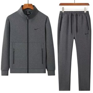 A luxurious tracksuit consisting of a gray zip-up jacket and matching gray sweatpants, both adorned with the Nike logo, hanging on wooden hangers against a white background.